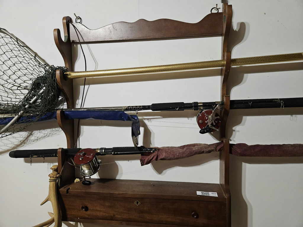 Wall-mounted fishing rod rack with reels, net, and tackle cabinet - image 1 of 5