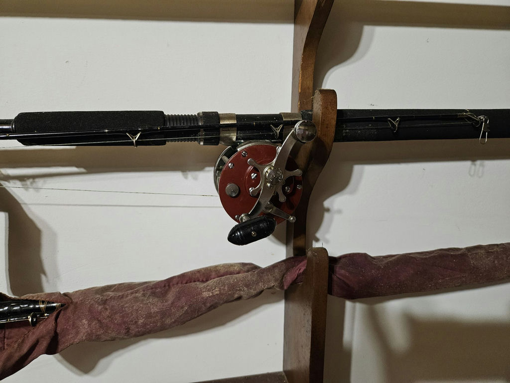 Wall-mounted fishing rod rack with reels, net, and tackle cabinet - image 4 of 5