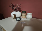 White ceramic vases, a carved tiki statue, a rope-handled jar, and a digital clock - thumbnail 2 of 7