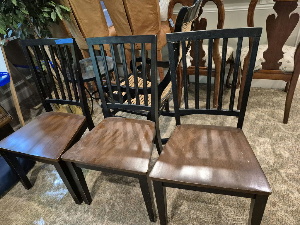 Set of three black slat-back wooden dining chairs with brown seats and a wooden table - image 3 of 5