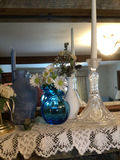 Blue Candles, Glass Vases, and Floral Arrangements on Lace Mantel - thumbnail 3 of 3
