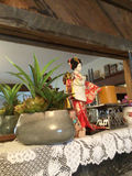 Decorative shelf arrangement with plants, a kimono-doll figurine, candles, and floral ceramics - thumbnail 3 of 5