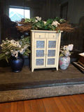 White cabinet with blue star-patterned doors surrounded by floral decor - thumbnail 1 of 1
