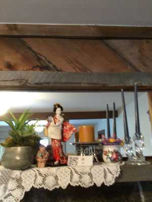 Decorative shelf arrangement with plants, a kimono-doll figurine, candles, and floral ceramics - Image 1 of 5