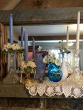 Blue Candles, Glass Vases, and Floral Arrangements on Lace Mantel - thumbnail 1 of 3