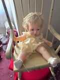 Vintage baby doll on a wooden rocking chair - thumbnail 1 of 5