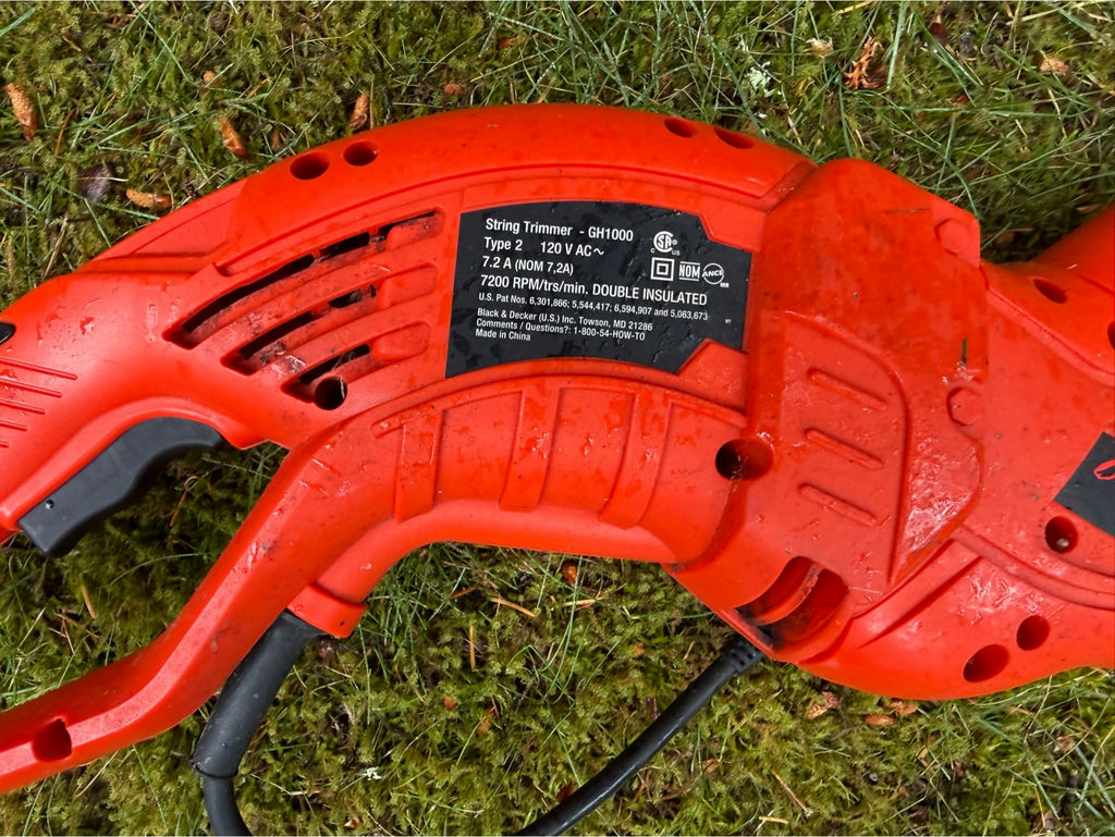 Red electric string trimmer and blue garden gnome statue - image 2 of 3