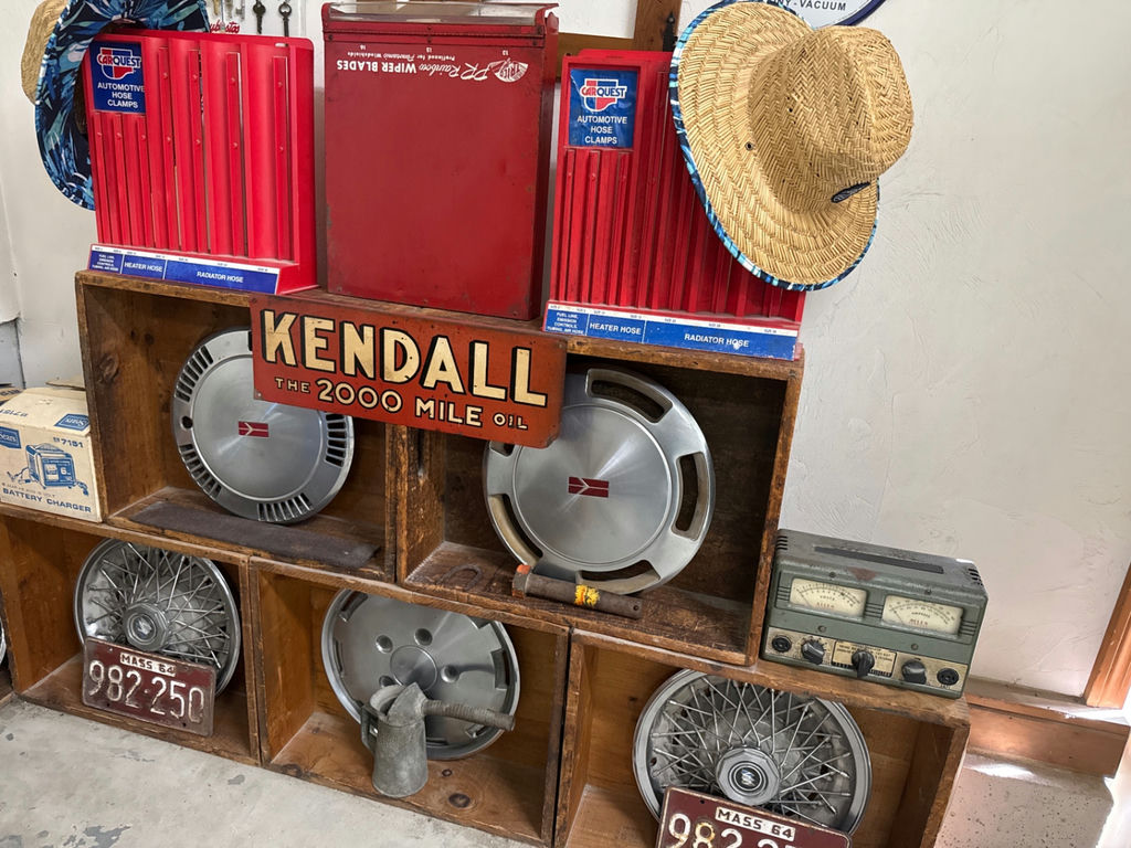 Vintage automotive parts display with Kendall oil sign and hubcaps - image 1 of 5