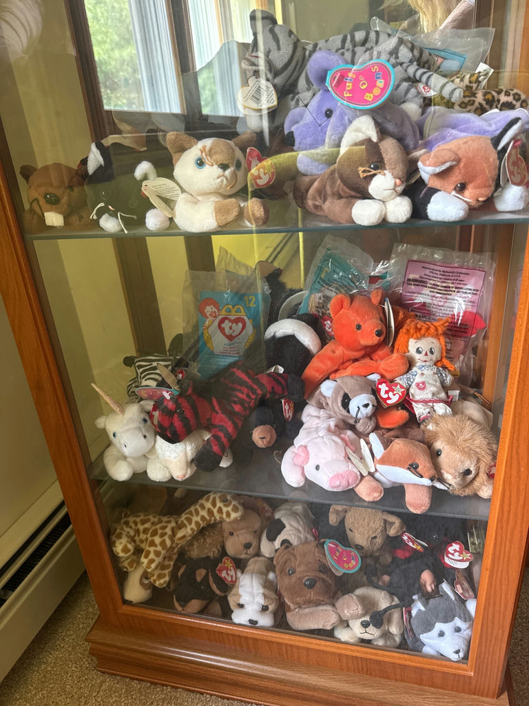 Glass display cabinet with plush stuffed animals - image 1 of 5