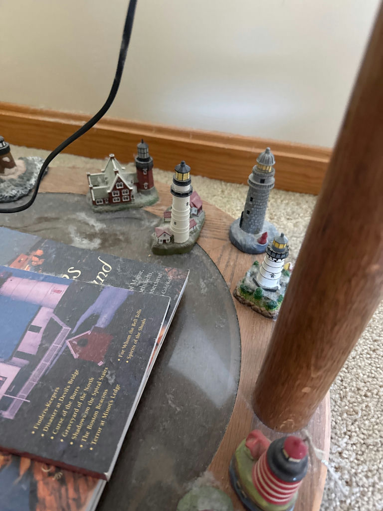 Lighthouse miniatures surrounding a book - image 3 of 3