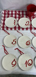 Twelve white ceramic plates with red numerals 1–12 and bird motif, each with red hanging ribbon - thumbnail 2 of 5