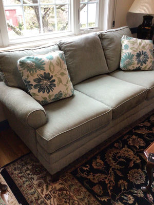 upholstered sofa with floral throw pillows - Image 1 of 4