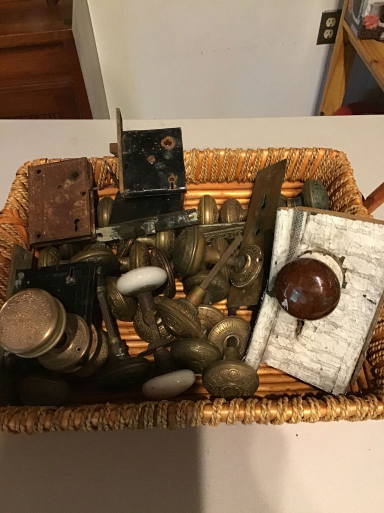 Assorted vintage door knobs and hardware in a basket - image 1 of 1