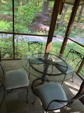 Round glass dining table with four cushioned metal chairs - thumbnail 1 of 4