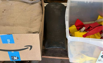 Assorted household items: box, curved plastic component with latch, bin of red and yellow straps, and towel - Image 1 of 5