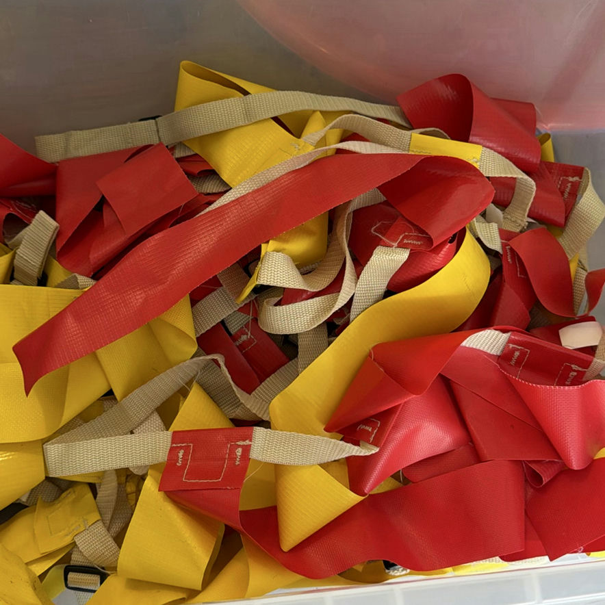 Assorted household items: box, curved plastic component with latch, bin of red and yellow straps, and towel - image 3 of 5