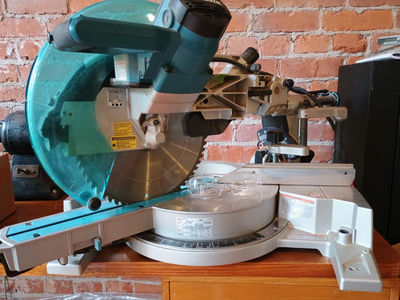 Makita sliding compound miter saw with safety glasses - Image 1 of 4