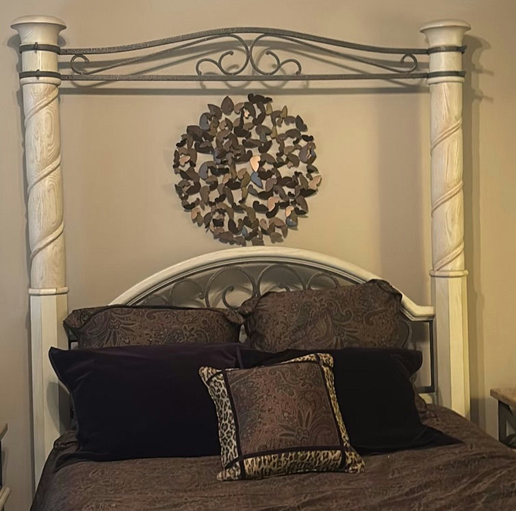 Cream four-poster bed with wrought-iron headboard and circular wall art - image 2 of 11