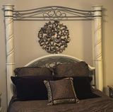 Cream four-poster bed with wrought-iron headboard and circular wall art - thumbnail 2 of 11