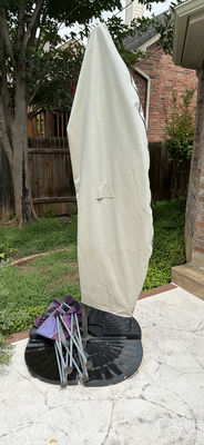 Patio umbrella with blue canopy and beige protective cover - Image 1 of 6