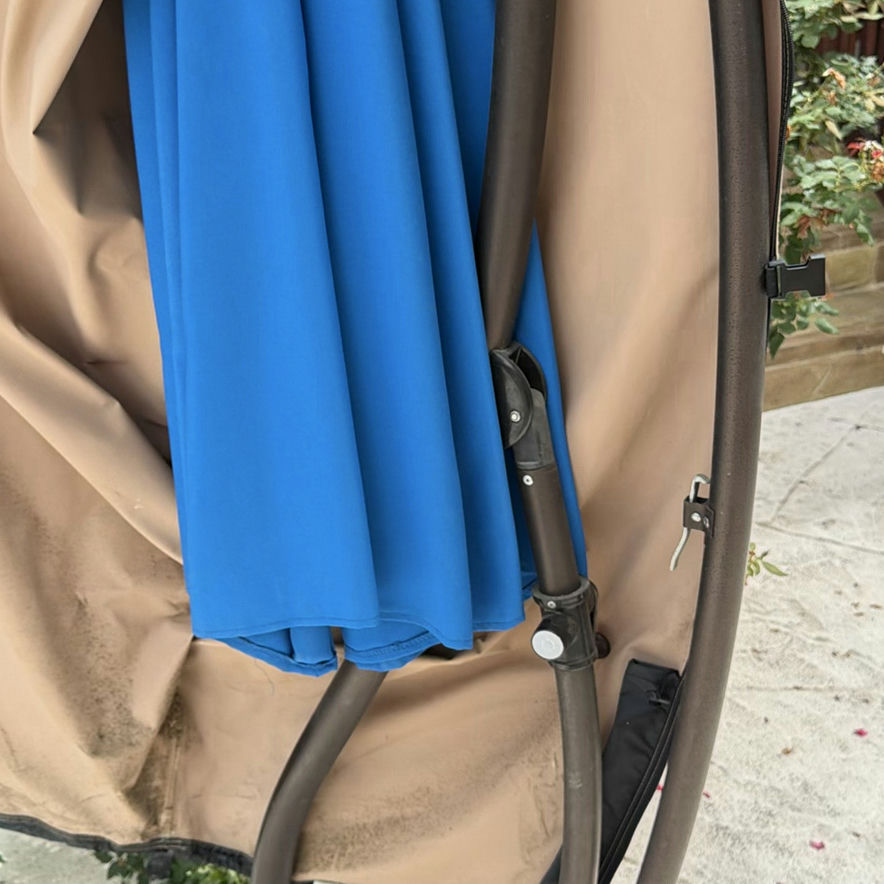 Beige folded patio umbrella with blue interior canopy on round base - image 5 of 5
