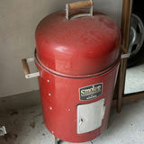 Red barrel-style smoker with wood chunks - thumbnail 1 of 5
