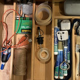 Assorted tools, adhesives, and maintenance supplies in a wooden organizer - thumbnail 4 of 5