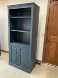 Blue wooden bookcase with open shelving and bottom cabinet. - thumbnail 1 of 3