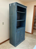 Blue wooden bookcase with open shelving and bottom cabinet. - thumbnail 2 of 3