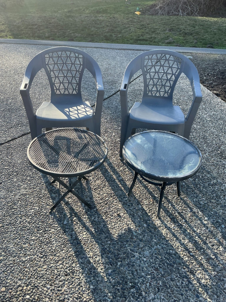 Two gray plastic patio chairs with lattice backs and two round tables (mesh and glass-top) - image 1 of 3