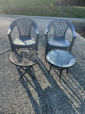 Two gray plastic patio chairs with lattice backs and two round tables (mesh and glass-top) - Image 1 of 3