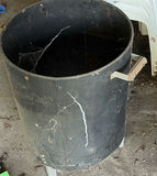 Stack of white plastic chairs and a black cylindrical metal trash can - thumbnail 4 of 4