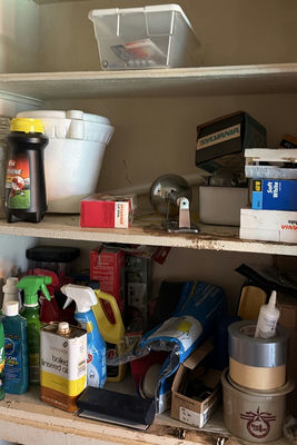 Garage shelf with cleaning products, oils, and hardware - Image 1 of 8