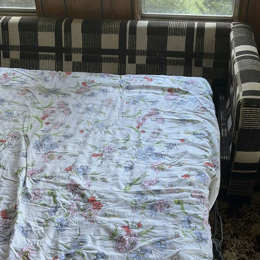 Plaid sleeper sofa with cushions and floral sheet - image 5 of 5
