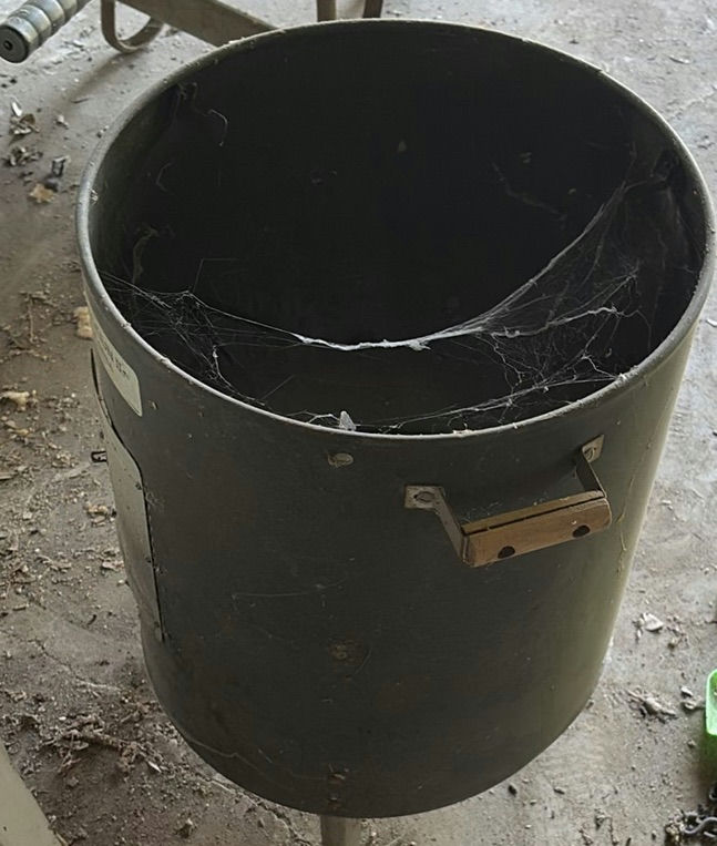 Stack of white plastic chairs and a black cylindrical metal trash can - image 3 of 4