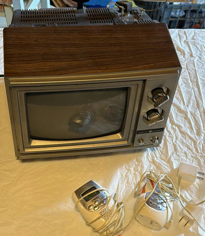 Vintage GE wood-veneer CRT television with two VTech handheld devices - image 1 of 6