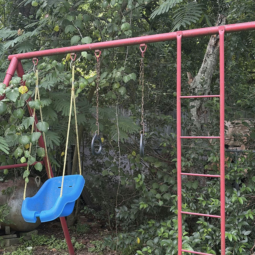 Red metal playground swing set with multiple swings and gym rings - image 5 of 5