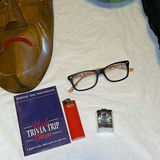 Assorted items: carved wooden mask, barometer, books, glasses, lighter, cushions, ball and circular object - thumbnail 4 of 8