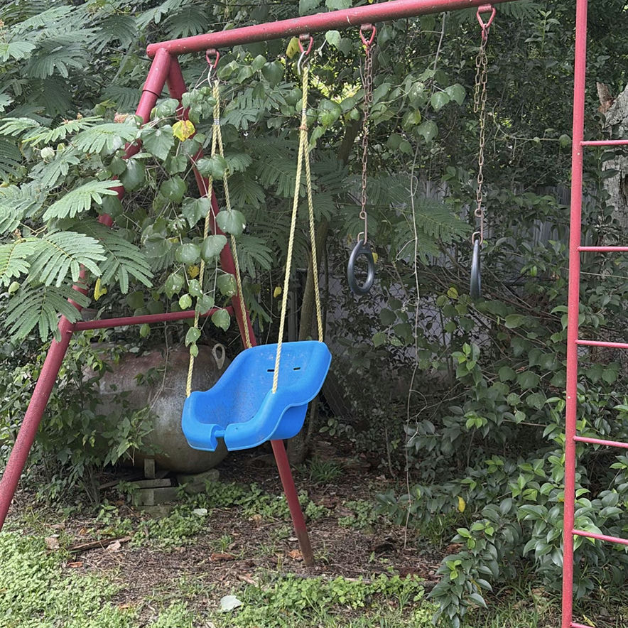 Red metal playground swing set with multiple swings and gym rings - image 4 of 5