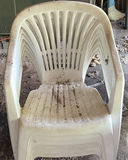 Stack of white plastic chairs and a black cylindrical metal trash can - thumbnail 2 of 4