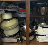 Assorted cookware and enamelware in a cabinet - thumbnail 1 of 10