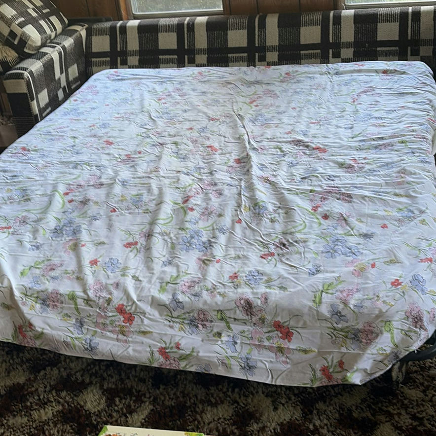Plaid sleeper sofa with cushions and floral sheet - image 4 of 5