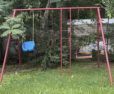 Red metal playground swing set with multiple swings and gym rings - Image 1 of 5